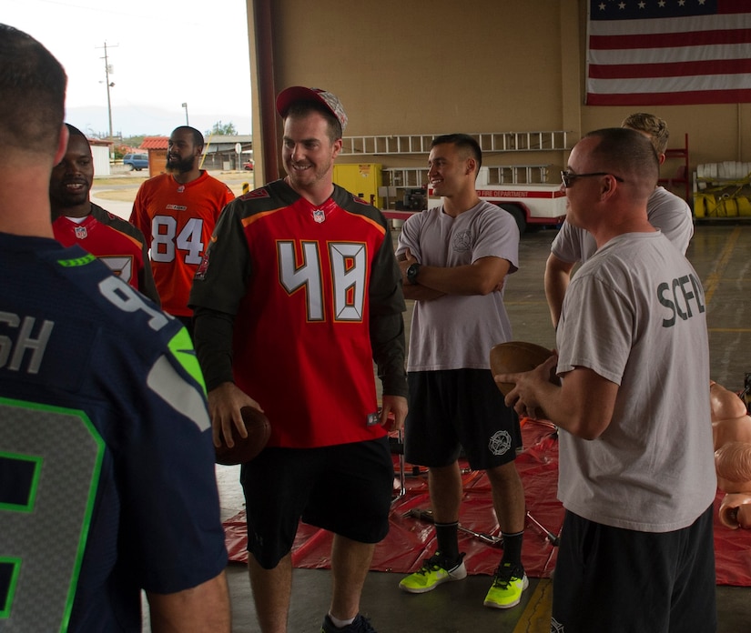 Firefighters with the 612th Air Base Squadron interact with NFL football players Feb. 7, 2016 at Soto Cano Air Base, Honduras as a part of a visit to the base hosted by the Armed Forces Entertainment for Super Bowl 50. (U.S. Air Force photo by Capt. Christopher Mesnard/Released)