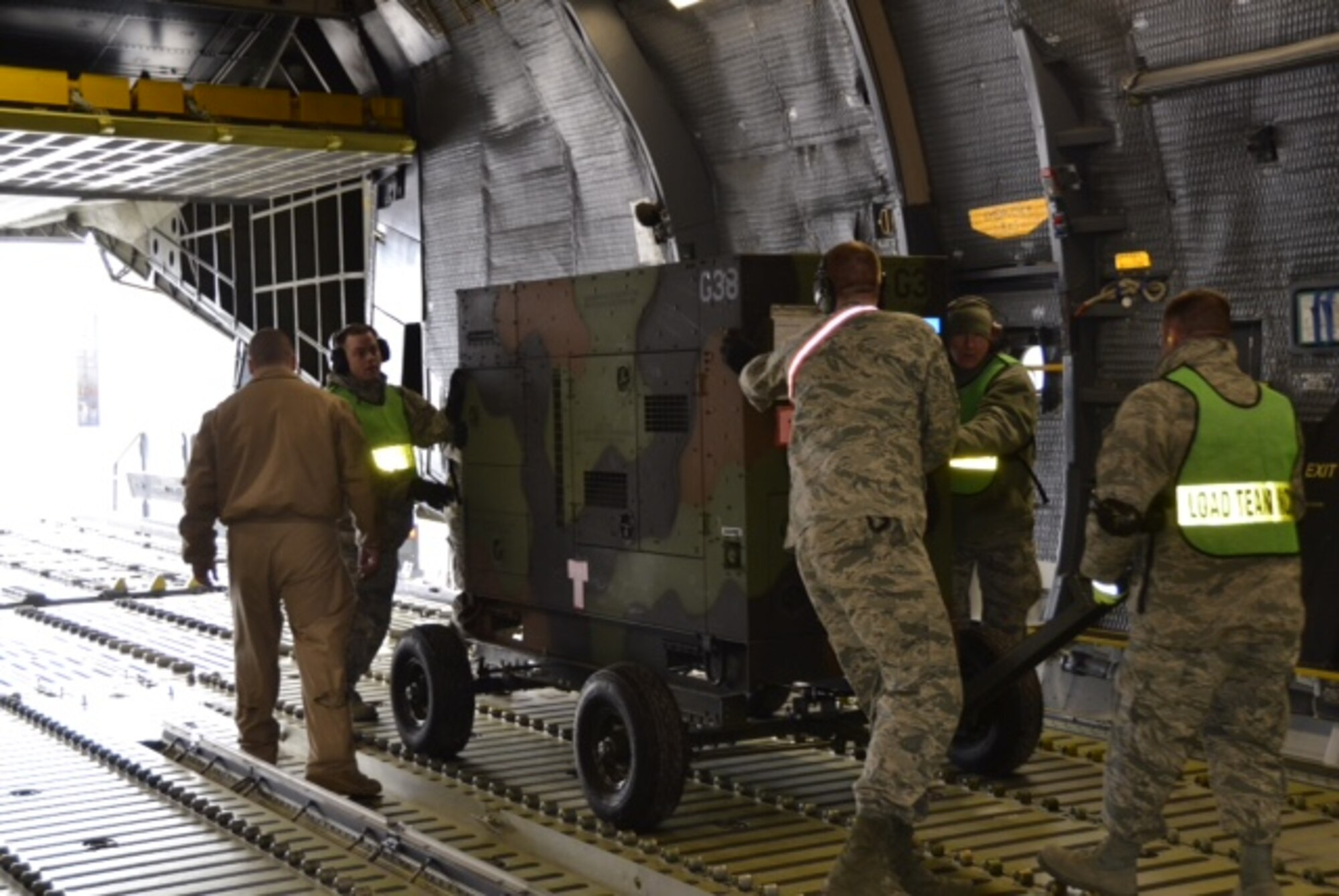 Airmen load cargo onto an aircraft in preparation for the 174th Attack Wing's deployment from Hancock Field Air National Guard Base in January, 2016. (Courtesy photo/Released)