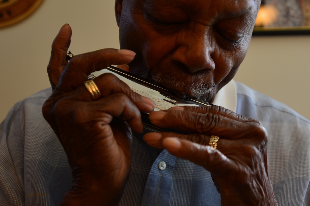 Retired U.S. Army Col. Aaron M. Dotson, a World War II and Vietnam War veteran, plays the harmonica in his room in Hampton, Va., Aug. 8, 2015. Dotson studied music at Fisk University in Nashville, Tenn., before changing his major to sociology with a minor in psychology. (U.S. Air Force photo by Staff Sgt. Natasha Stannard)