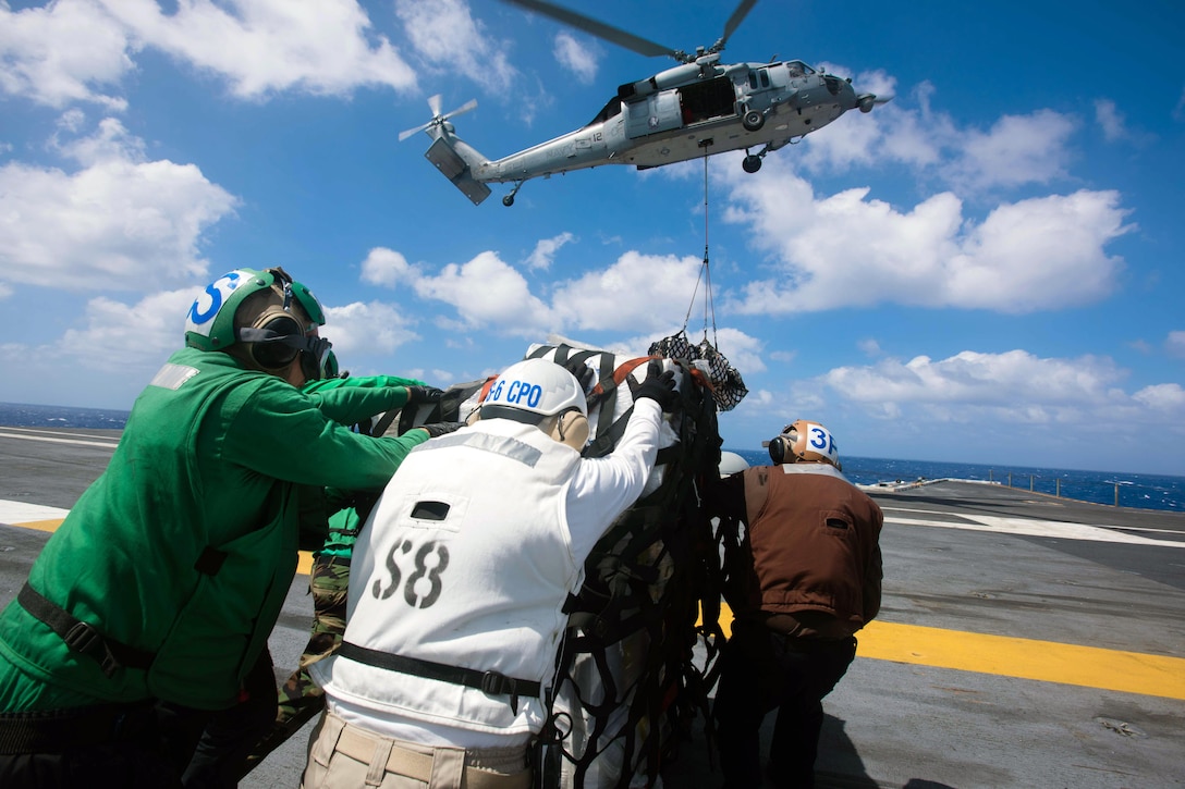 Sailors adjust a pallet of cargo on the flight deck of the USS John Stennis during a replenishment at sea with the USNS Rainier in the Pacific Ocean, Feb. 12, 2016. The Stennis is on a regularly scheduled western Pacific deployment. Navy photo by Petty Officer 3rd Class Kenneth Rodriguez Santiago