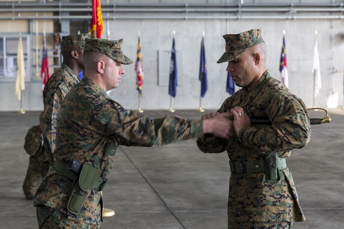 Lt. Col. Kolter Miller, left, Marine Aviation Logistics Squadron 12 commanding officer, passes the sword of office to Sgt. Maj. Edwin Mota, newly appointed MALS-12 sergeant major, during a relief and appointment ceremony at Marine Corps Air Station Iwakuni, Japan, Feb. 12, 2016. Sgt. Maj. Darnell Richardson, outbound MALS-12 sergeant major, relinquished his duties to Mota. The passing of the sword of office represents the transferring of duties and responsibilities from one sergeant major to another.