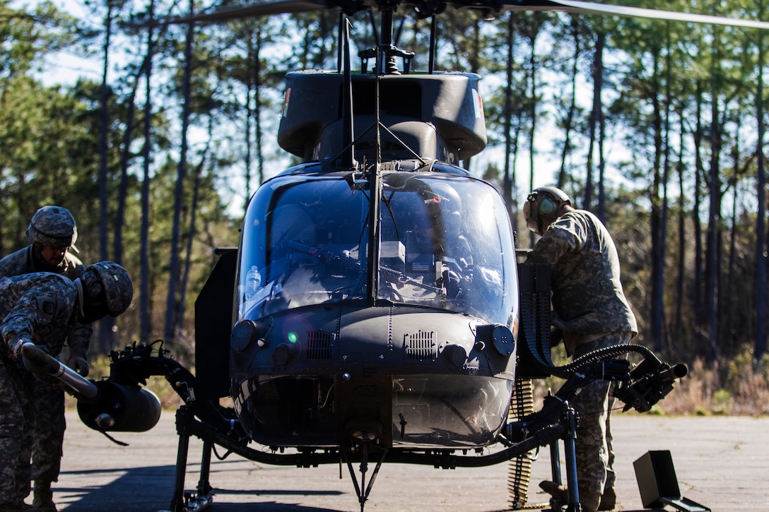 Soldiers load flechette rockets and .50-caliber machine gun rounds onto an OH-58 Kiowa Warrior helicopter before the unit's aerial gunnery exercise on Marine Corps Outlying Field Atlantic, N.C., Feb. 8, 2016. Army photo by Staff Sgt. Christopher Freeman