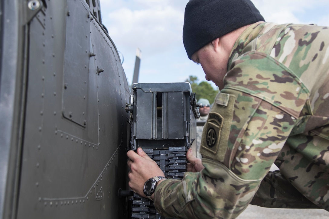 Army Spc. Jeff Jacobson reinstalls a .50-caliber belt chute after routine maintenance checks on a Kiowa Warrior helicopter on Marine Corps Outlying Field Atlantic, N.C., Feb. 9, 2016. Jacobson is a helicopter mechanic assigned to the 82nd Airborne Division’s 17th Cavalry Regiment, 82nd Combat Aviation Brigade. Army photo by Staff Sgt. Christopher Freeman