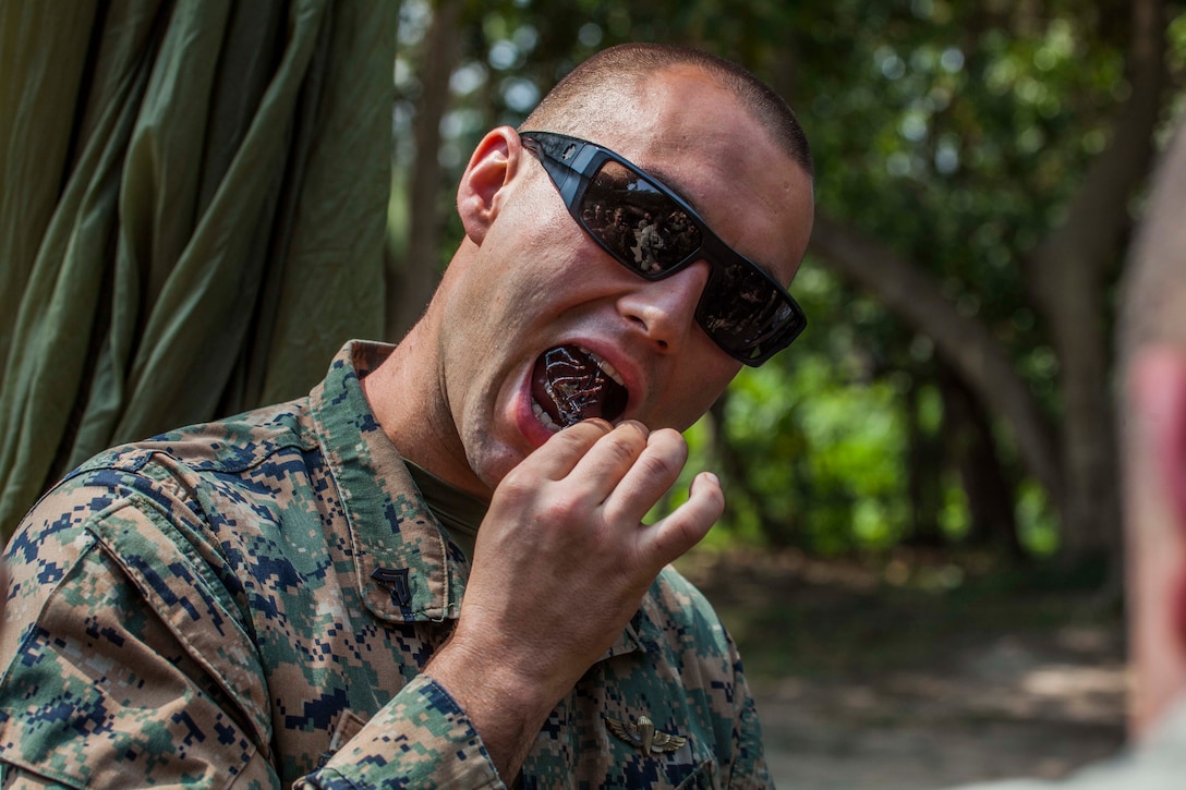 Marine Corps Cpl. Sam Teifke eats a live scorpion during jungle survival training led by Thai reconnaissance marines during exercise Cobra Gold 16 in Sattahip, Thailand, Feb. 8, 2016. Teifke is assigned to Maritime Raid Force, 31st Marine Expeditionary Unit. Marine Corps photo by Gunnery Sgt. Ismael Pena