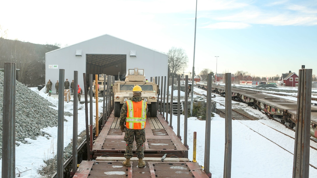 A Marine with 2nd Marine Expeditionary Brigade guides a Humvee onto a railcar in Hell, Norway, Feb. 12, 2016. The rail operations moved vehicles and equipment prepositioned in caves here to the training area in preparation for Exercise Cold Response 16, comprised of 13 allied and partner nations, and over 16,000 troops, starting later this month. 