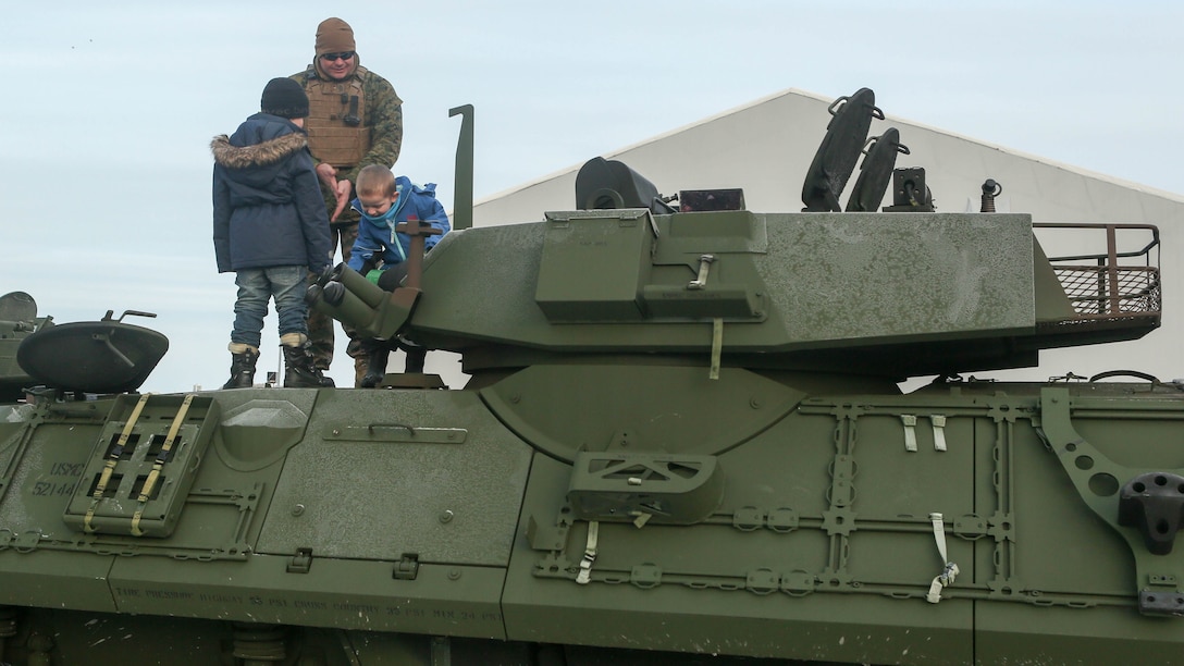 A Marine with 2nd Marine Expeditionary Brigade shows local children around a light armored vehicle at Hell Station in Hell, Norway, Feb. 12. Tons of combat vehicles and equipment were transported by rail to Rena, Norway, where the 2nd Marine Expeditionary Brigade’s ground combat element will take part in live-fire exercise in the coming days. The rail operations moved vehicles and equipment prepositioned in caves here to the training area in preparation for Exercise Cold Response 16, comprised of 13 allied and partner nations, and over 16,000 troops, starting later this month. 