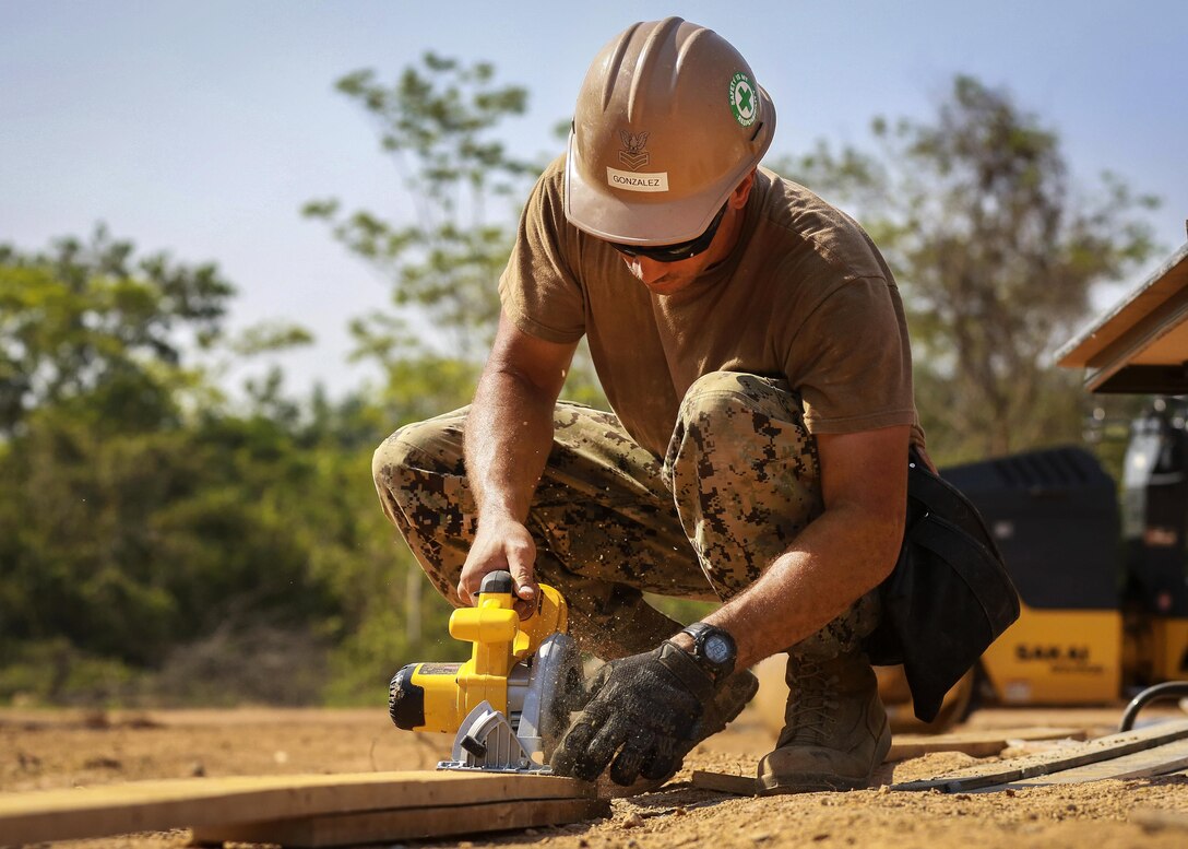 Navy Petty Officer 1st Class Antonio Gonzalez uses an electric saw to cut boards while participating in the construction of a community center during exercise Cobra Gold at the Ban Sa Yai School, in Trat, Thailand, Feb. 3, 2016. Gonzalez is a builder assigned to Naval Mobile Construction Battalion 3. Marine Corps photo by Lance Cpl. Miguel A. Rosales