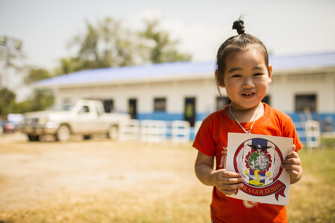 A child holds a sticker during the construction of a classroom at the Wat Ban Mak school, Saraburi, Thailand, during exercise Cobra Gold, Feb. 14, 2016. Cobra Gold, in its 35th iteration, focuses on humanitarian civic action, community engagement, and medical activities to support the needs and humanitarian interest of civilian populations around the region.