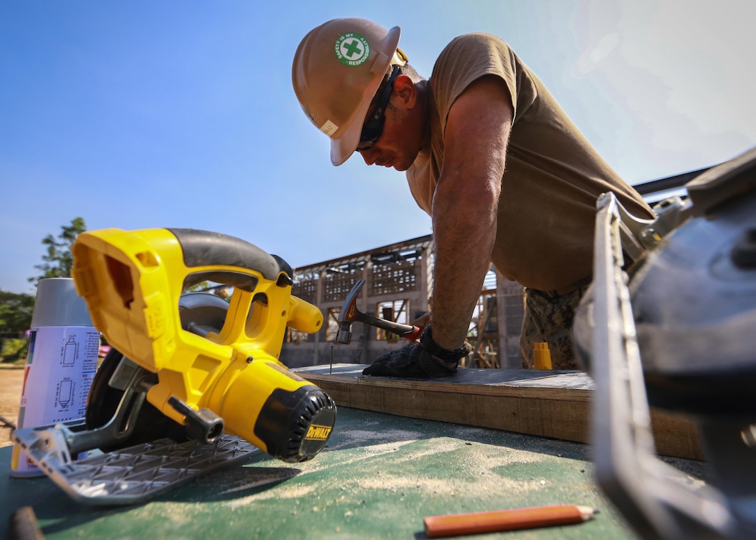 Navy Petty Officer 1st Class Antonio Gonzalez hammers boards together while participating in the construction of a community center during exercise Cobra Gold at the Ban Sa Yai School, in Trat, Thailand, Feb. 3, 2016. Gonzalez is a builder assigned to Naval Mobile Construction Battalion 3. Marine Corps photo by Lance Cpl. Miguel A. Rosales