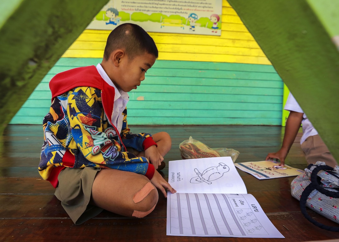 A student at the Ban Sa Yai School in Trat, Thailand, looks through a coloring book during exercise Cobra Gold, Feb. 3, 2016. Marine Corps photo by Lance Cpl. Miguel A. Rosales