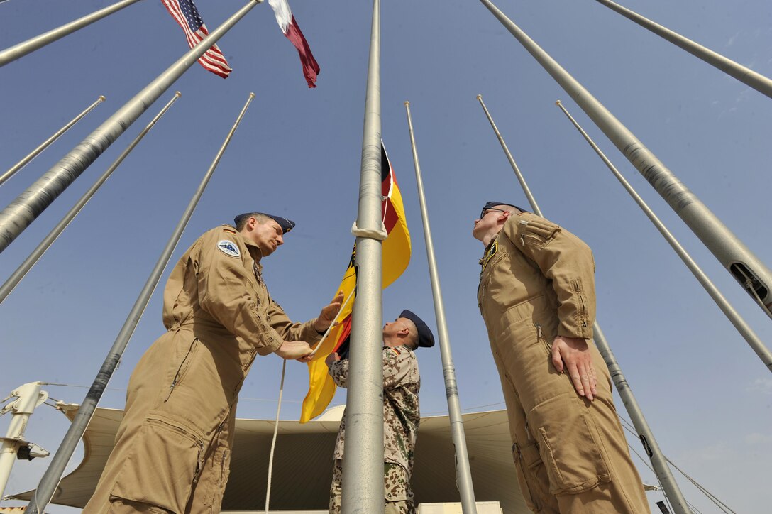 German Air Force members raise the German flag during a ceremony at Al Udeid Air Base, Qatar, Feb. 8, 2016. The ceremony recognized the addition of Germany to the coalition supporting Operation Inherent Resolve. (U.S. Air Force photo by Master Sgt. Joshua Strang)