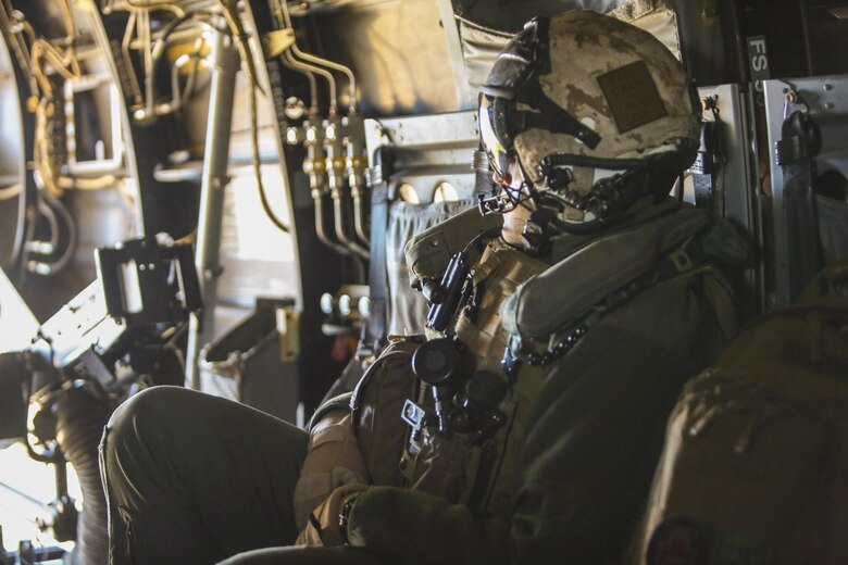 Staff Sgt. Anthony C. Knight, a crew chief with Marine Medium Tiltrotor Squadron 365, observes the outside surroundings from inside a MV-22B Osprey during section confined area landings, Feb. 10, 2016. Marines with VMM-365 out of Marine Corps Air Station New River, N.C.,  flew to a landing zone, which allowed pilots to practice CALs in their Osprey’s and then flew several miles off the coast to practice shooting the M2 Browning .50-caliber machine gun from the back of the aircraft. (U.S. Marine Corp photo by Lance Cpl. Aaron K. Fiala/Released)