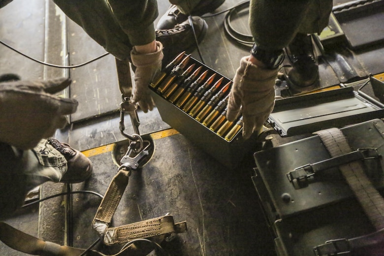 Staff Sgt. Anthony C. Knight, a crew chief with Marine Medium Tiltrotor Squadron 365, prepares a box of belt fed .50-caliber rounds for a gunner during a live fire training session off the coast of Marine Corps Air Station New River, N.C., Feb. 10, 2016. Marines with VMM-365 flew to a landing zone, which allowed pilots to practice CALs in their MV-22B Osprey’s and then flew several miles off the coast to practice shooting the M2 Browning .50-caliber machine gun from the back of the aircraft. (U.S. Marine Corp photo by Lance Cpl. Aaron K. Fiala/Released)