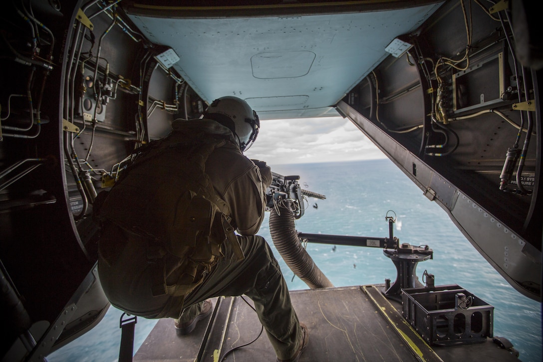 Lance Cpl. Jarod L. Smith, a crew chief with Marine Medium Tiltrotor Squadron 365, fires a mounted M2 Browning .50-caliber machine gun from the back of the MV-22B Osprey during a live fire training session off the coast of Marine Corps Air Station New River, N.C., Feb. 10, 2016. Marines with VMM-365 flew to a landing zone, which allowed pilots to practice CALs in their Osprey’s and then flew several miles off the coast to practice their proficiency with the .50-caliber  machine gun. (U.S. Marine Corp photo by Lance Cpl. Aaron K. Fiala/Released)