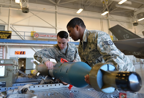 Staff Sgt. Timothy Gaulden, a 33rd Aircraft Maintenance Squadron weapons load crew chief, and Airman 1st Class Jacob Robinson, a 33rd AMXS weapons load crew member, attach a joint direct attack munition to a missile-guided bomb unit for the first F-35A Lightning II load competition at Eglin Air Force Base, Fla., Feb. 5, 2016. During the event, Airmen competed in a uniform inspection, a written test, a tool box inspection, and an integrated load. (U.S. Air Force photo/Senior Airman Andrea Posey)