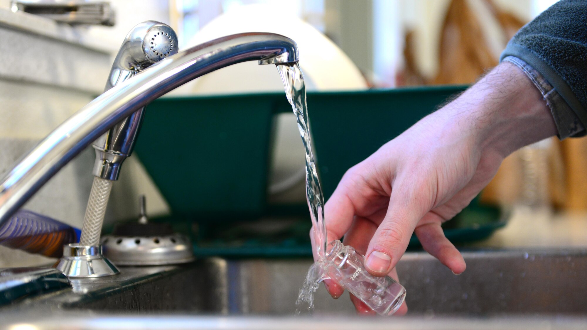 U.S. Air Force Airman 1st Class Chasten Gibbs, 354th Medical Group bioenvironmental engineering apprentice, collects a water sample, Feb. 3, 2016 at Eielson Air Force Base, Alaska. Gibbs uses the water sample to test the pH levels, and for chlorine and bacteria in the water. (U.S. Air Force photo by Airman 1st Class Cassandra Whitman/Released)