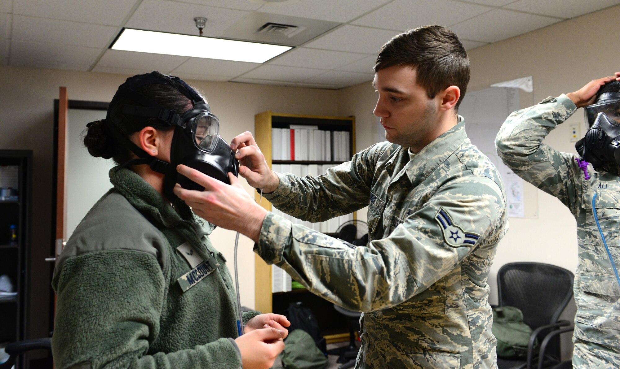U.S. Air Force Airman 1st Class Chasten Gibbs, 354th Medical Group bioenvironmental engineering apprentice, helps Airmen put their masks on for fit testing, Feb. 3, 2016 at Eielson Air Force Base, Alaska. Fit testing is done to ensure Airmen have properly fitting masks so there is no exposure to chemical warfare agents or respirable particulates.  (U.S. Air Force photo by Airman 1st Class Cassandra Whitman/Released)