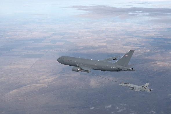 A KC-46A Pegasus refuels an F/A-18 Hornet with its hose and drogue system. (Boeing photo/John Parker)
