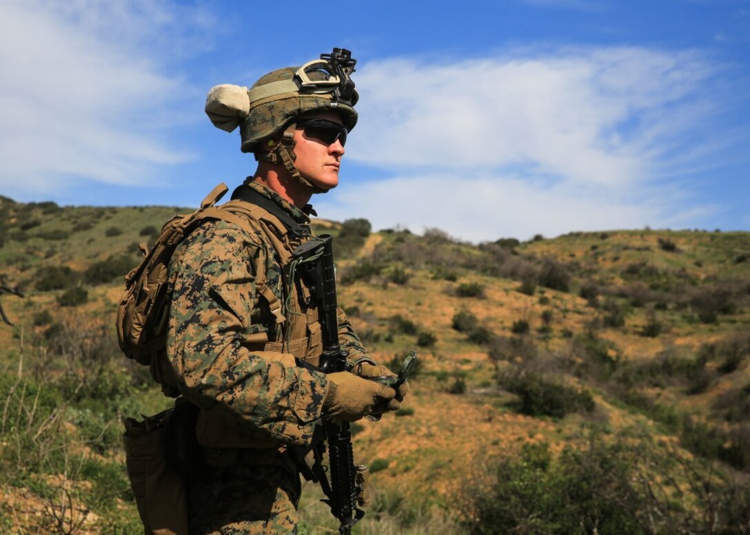 A Marine orients his team toward the location of a simulated downed pilot during a tactical recovery of aircraft and personnel, or TRAP, training scenario at Camp Pendleton, Calif., Feb. 10, 2016. The TRAP training is meant to prepare Marines on essential procedures used to tactically recover personnel, equipment or aircraft by inserting the recovery force to the objective location. The Marine is with 2nd Battalion, 4th Marine Regiment, 1st Marine Division. (U.S. Marine Corps photo by Lance Cpl. Devan K. Gowans/Released)