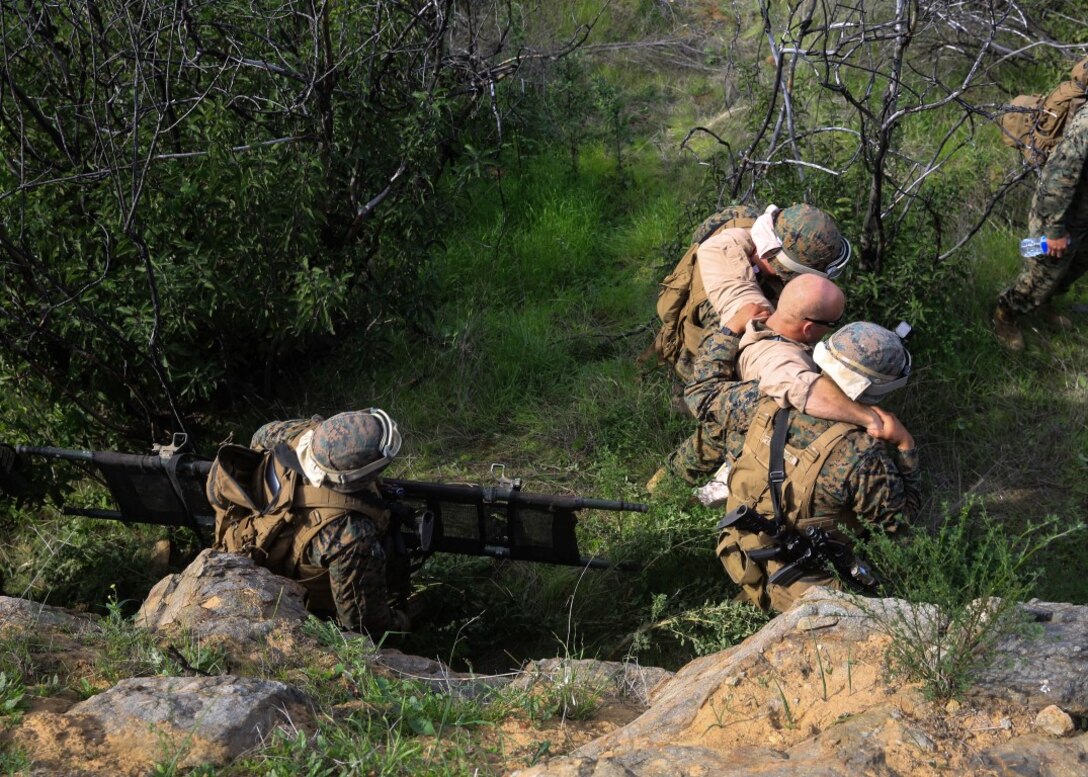A Marine aid and litter team retrieves a simulated down pilot during a tactical recovery of aircraft and personnel, or TRAP, training scenario at Camp Pendleton, Calif., Feb. 10, 2016. In preparation for their upcoming deployment with the 31st Marine Expeditionary Unit, the TRAP scenario offers the Marines of Weapons Company, 2nd Battaion, 4th Marine Regiment, 1st Marine Divison, a secondary skillset in additon to their own primary duties, refining their ability to efficiently conduct a recovery mission. (U.S. Marine Corps photo by Lance Cpl. Devan K. Gowans/Released)