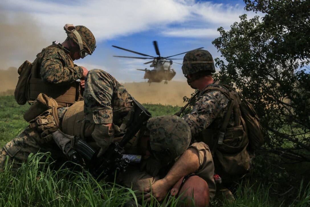 Marines protect a simulated injured person from the rotor wash of a CH-53E Super Stallion transport helicopter during a tactical recovery of aircraft and personnel, or TRAP, training scenario at Camp Pendleton, Feb. 10, 2016. TRAP is used to tactically recover personnel, equipment or aircraft by inserting the recovery force to the objective location. The Marines are with Weapons Company, 2nd Battalion, 4th Marine Regiment, 1st Marine Division. (U.S. Marine Corps photo by Lance Cpl. Devan K. Gowans/Released)