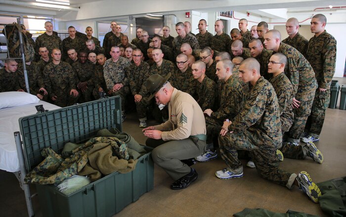 A drill instructor of Kilo Company, 3rd Recruit Training Battalion, teaches recruits how to label their personal items during pick up at Marine Corps Recruit Depot San Diego, Feb. 12. In the first hours recruits are with their drill instructors, they learn the rules and regulations of recruit training, covering everything from how to act in the squad bay to how to speak to the drill instructors. Annually, more than 17,000 males recruited from the Western Recruiting Region are trained at MCRD San Diego. Kilo Company is scheduled to graduate May 6.