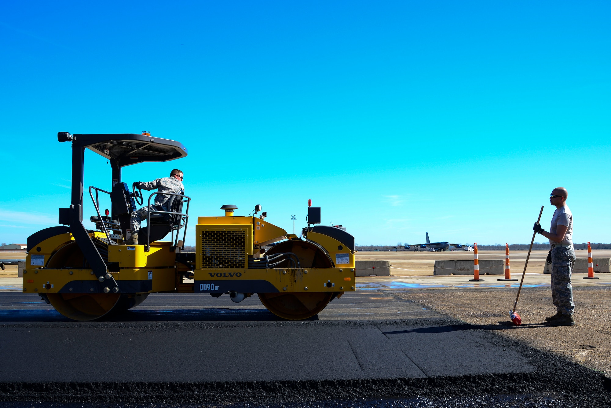 Senior Airman Jeremy Bisaccio and Tech. Sgt. David Torres, 2nd Civil Engineer Squadron heavy equipment operators, back a roller over fresh asphalt at Barksdale Air Force Base, La., Feb. 11, 2016. The paving project served as a training opportunity to give the Airmen experience with pavers and rollers, which they could also use in deployed locations. (U.S. Air Force photo/Senior Airman Benjamin Raughton)
