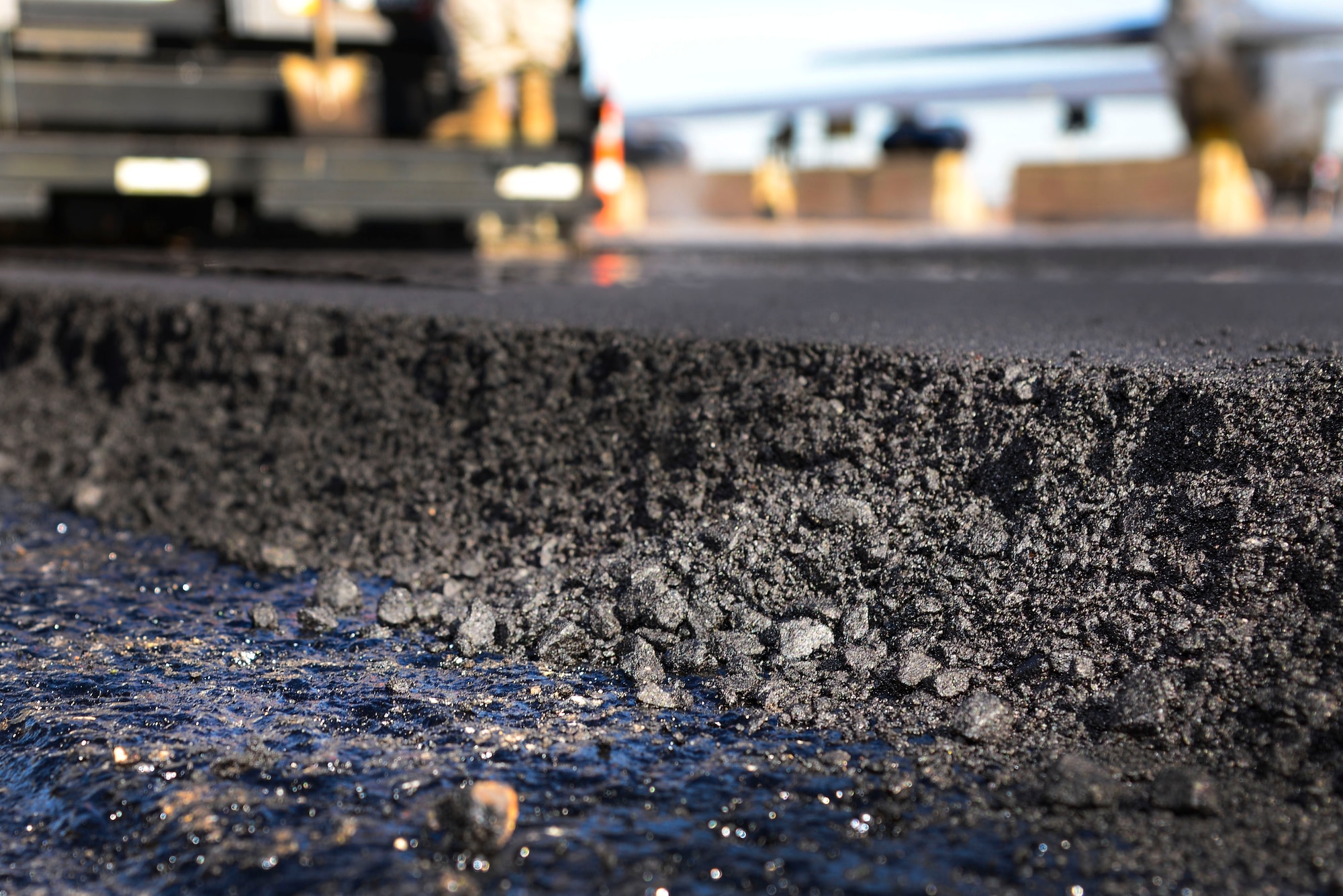 Fresh asphalt is laid over a tack coat, an adhesive used to bind fresh asphalt to the ground on Barksdale Air Force Base, La., Feb. 11, 2016. Asphalt construction is only performed when the temperature is 50 degrees or more. (U.S. Air Force photo/Senior Airman Benjamin Raughton)