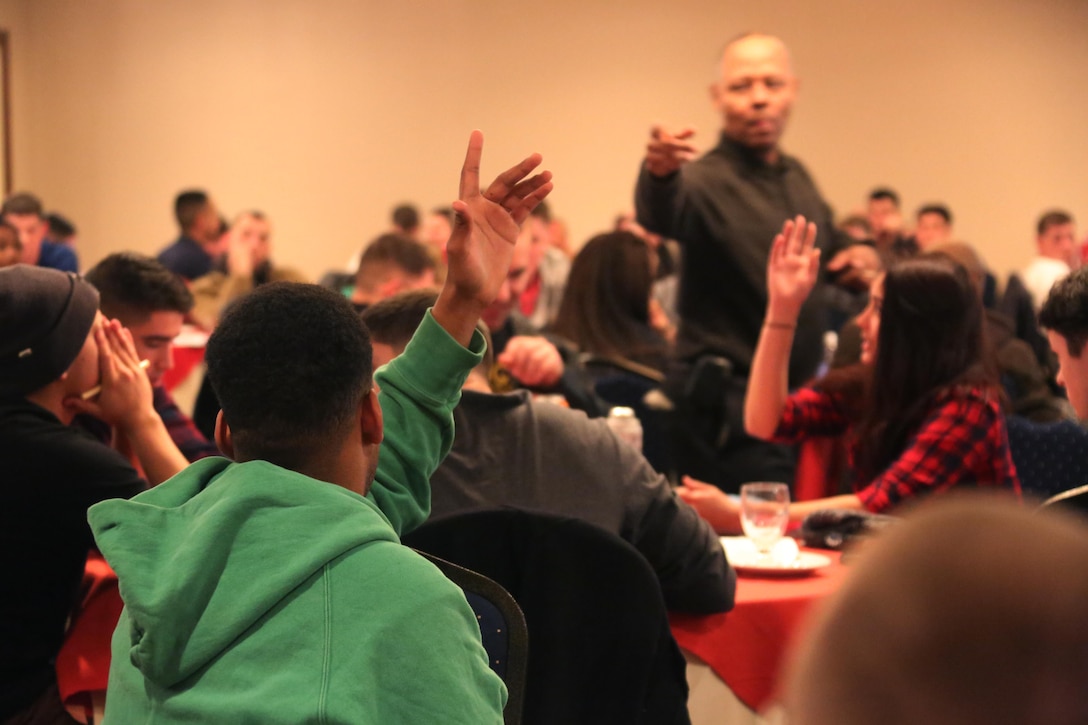 A crowd of service members raise their hands during an interactive exercise during a Single Marine and Sailor Personal Growth Retreat in New Bern, N.C., Jan. 29-30, 2016. Marines and Sailors from across 2nd Marine Aircraft Wing gathered for a detailed seminar that encompassed basic skills like coping with stress, relationship building and self-awareness. The seminar was led by chaplains with 2nd MAW and focused on helping Marines and Sailors grow as individuals to get them mentally ready for forward deployment and to promote self-improvement.  (U.S. Marine Corps photo by Cpl. N.W. Huertas/Released) 