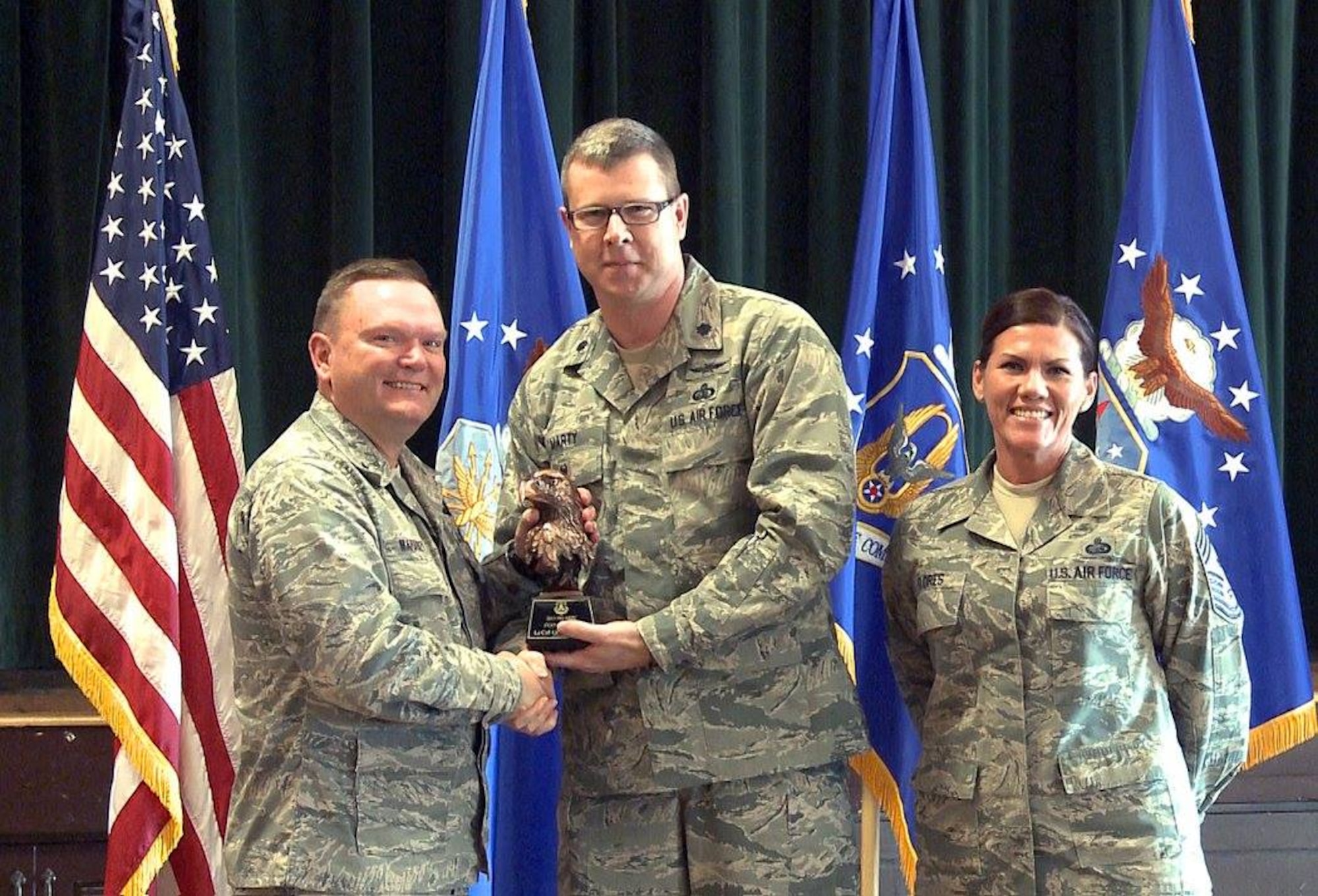Brig. Gen. Samuel “Bo” Mahaney, Air Reserve Personnel Center commander, and Chief Master Sgt. Ruthe Flores, ARPC command chief, present the ARPC Field Grade Officer of the Year award to Lt. Col. Gregory Marty. Mahaney honored ARPC’s 2015 outstanding performers of the year Feb. 16, 2016, at the Heritage Eagle Bend Country Club in Aurora, Colo. (U.S. Air Force photo/Quinn Jacobson)
