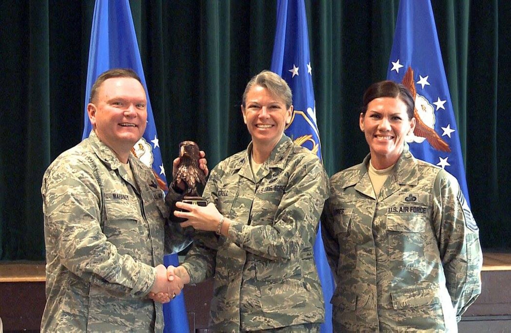 Brig. Gen. Samuel “Bo” Mahaney, Air Reserve Personnel Center commander, and Chief Master Sgt. Ruthe Flores, ARPC command chief, present the Category I, Non-Supervisory Civilian of the Year award to Col. Carolyn Stickell, Headquarters Individual Reservist Readiness and Integration Organization commander, who accepted the award on behalf of Francisco Rivera. Mahaney honored ARPC’s 2015 outstanding performers of the year Feb. 16, 2016, at the Heritage Eagle Bend Country Club in Aurora, Colo. (U.S. Air Force photo/Quinn Jacobson)