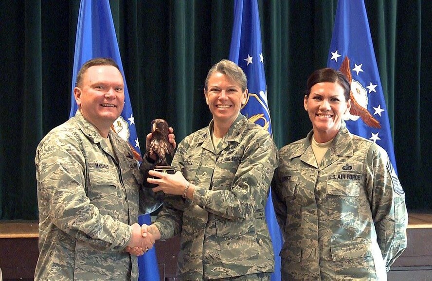 Brig. Gen. Samuel “Bo” Mahaney, Air Reserve Personnel Center commander, and Chief Master Sgt. Ruthe Flores, ARPC command chief, present the Category I, Non-Supervisory Civilian of the Year award to Col. Carolyn Stickell, Headquarters Individual Reservist Readiness and Integration Organization commander, who accepted the award on behalf of Francisco Rivera. Mahaney honored ARPC’s 2015 outstanding performers of the year Feb. 16, 2016, at the Heritage Eagle Bend Country Club in Aurora, Colo. (U.S. Air Force photo/Quinn Jacobson)