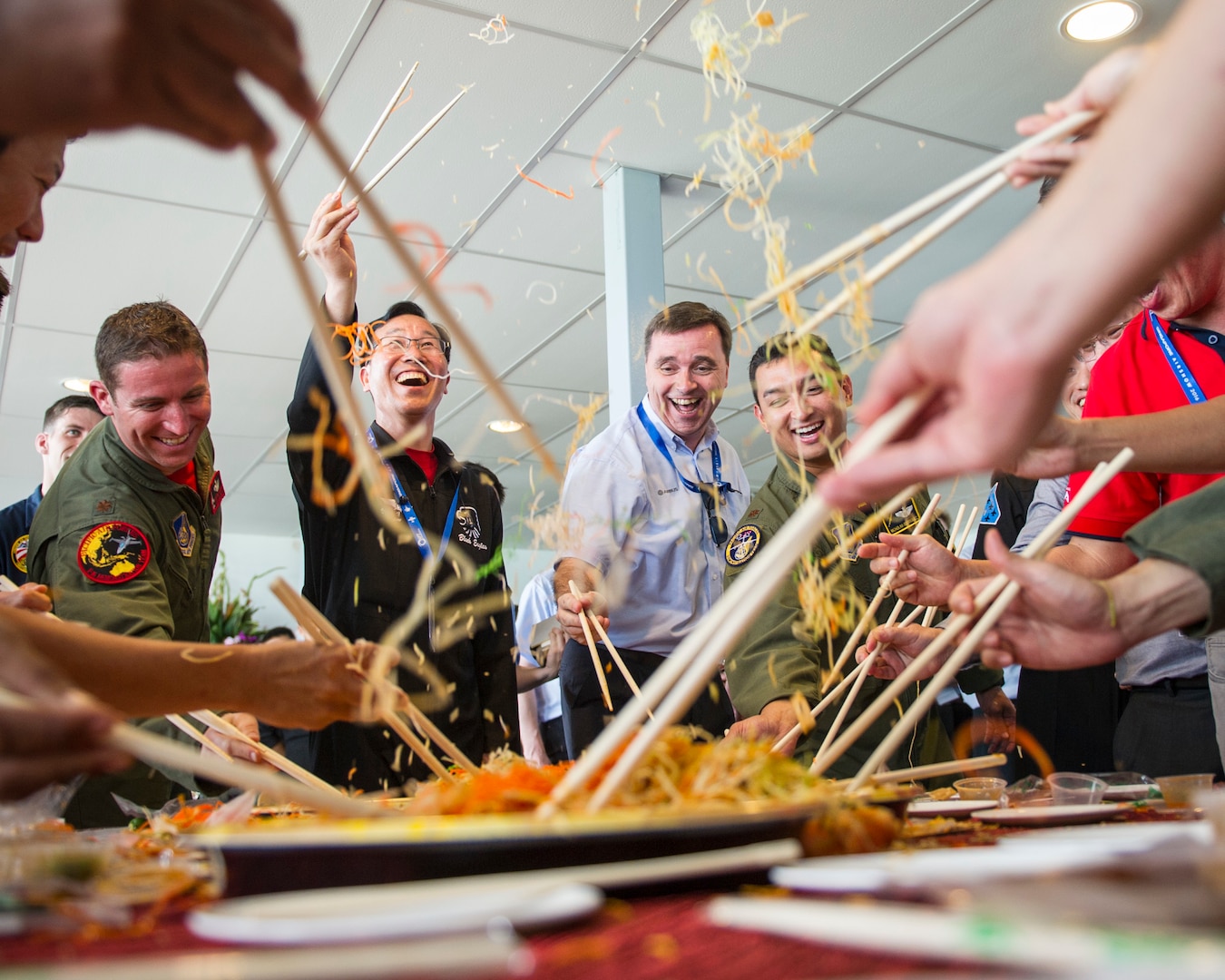 Aerial demonstration team members from the U.S., Singapore, Republic of Korea, Malaysia and France partake in the Lunar New Year tradition of a “Lo Hei” salad toss during a patch exchange ceremony prior to the Singapore International Airshow, at Changi Airport, Singapore, Feb. 14, 2016. The custom is meant to bring good fortune for the new year and offered Airmen from several nations a fun experience to launch them into the airshow. The Singapore International Airshow is focused on building stronger relationships between the U.S., Singapore and the international community. (U.S. Air Force photo by Capt. Raymond Geoffroy/Released)