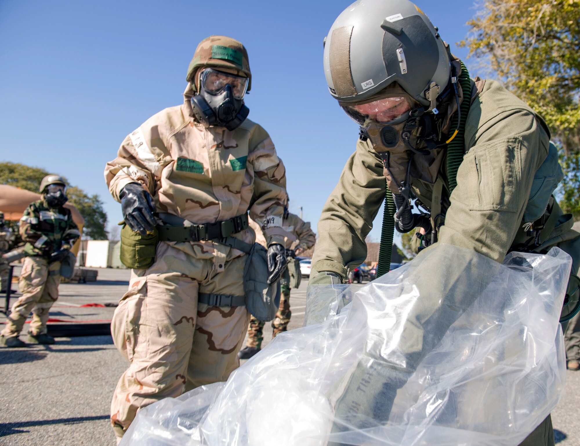 U.S. Air Force Senior Airman Jessica Burrell, 347th Operations Support Squadron aircrew flight equipment technician, instructs Airman 1st Class Taylor Doss, 71st Rescue Squadron loadmaster, to remove garments during Aircrew Contamination Control Area training, Feb. 11, 2016, at Moody Air Force Base, Ga. During the training, AFE remove aircrew members from chemical agent exposure and instruct them on proper usage of the aircrew eye and respiratory protection system. (U.S. Air Force photo by Airman 1st Class Greg Nash/Released) 