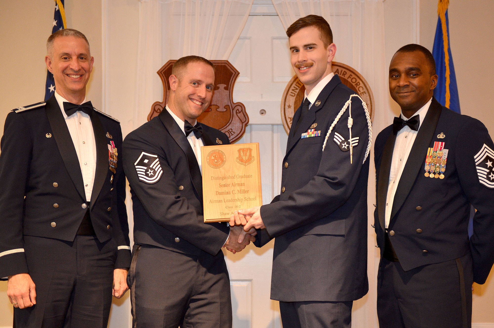 U.S. Air Force Senior Airman Damian Miller, 31st Intelligence Squadron, receives a Distinguished Graduate Award for the Senior Master Sgt. David B. Reid Airman Leadership School Class 16-2 from Master Sgt. William Byrd, 20th Force Support Squadron first sergeant, at Shaw Air Force Base, S.C., Feb. 11, 2016. Only Airmen in the top 10 percent of the class graduate with this prestigious award. (U.S. Air Force photo by Senior Airman Diana M. Cossaboom)