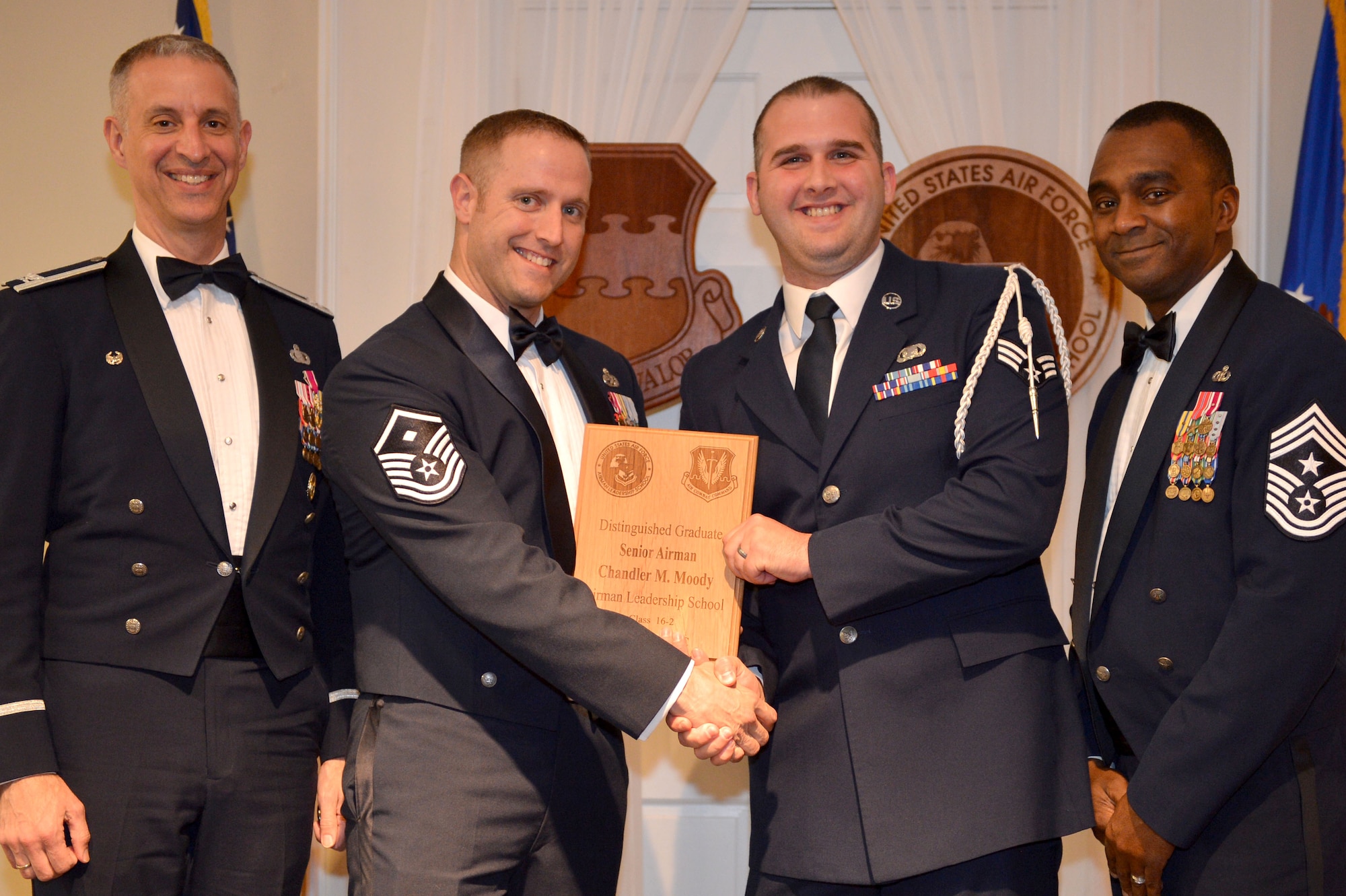 U.S. Air Force Senior Airman Chandler Moody, 31st Intelligence Squadron, receives a Distinguished Graduate Award for the Senior Master Sgt. David B. Reid Airman Leadership School Class 16-2 from Master Sgt. William Byrd, 20th Force Support Squadron first sergeant, at Shaw Air Force Base, S.C., Feb. 11, 2016. Only Airmen in the top 10 percent of the class graduate with this prestigious award. (U.S. Air Force photo by Senior Airman Diana M. Cossaboom)
