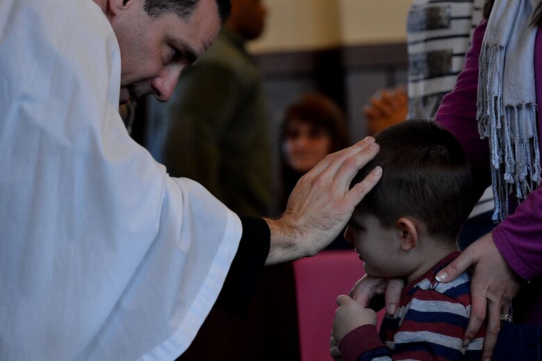 U.S. Air Force Chaplain (Capt.) James Finley, 20th Fighter Wing chaplain, rubs ashes on the forehead of a child during an Ash Wednesday service at the Friendship Chapel at Shaw Air Force Base, S.C., Feb. 10, 2016. Maintaining one’s spiritual resiliency is an integral part of Comprehensive Airman Fitness. (U.S. Air Force photo by Senior Airman Michael Cossaboom)