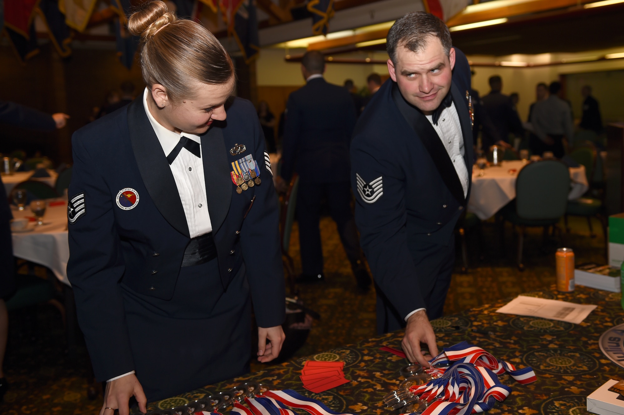 Tech. Sgt. James Lee (right) and Staff Sgt. Jessica Raab, Julius A. Kolb Airman Leadership instructors, organize medals during the ALS graduation at Joint Base Lewis-McChord, Wash., Feb. 11, 2016. The instructors spend more than 172 hours in the classroom, per class training new non-commissioned officers in the Air Force Airmen, Coast Guard, Army. (U.S. Air Force photo/Staff Sgt. Naomi Shipley)