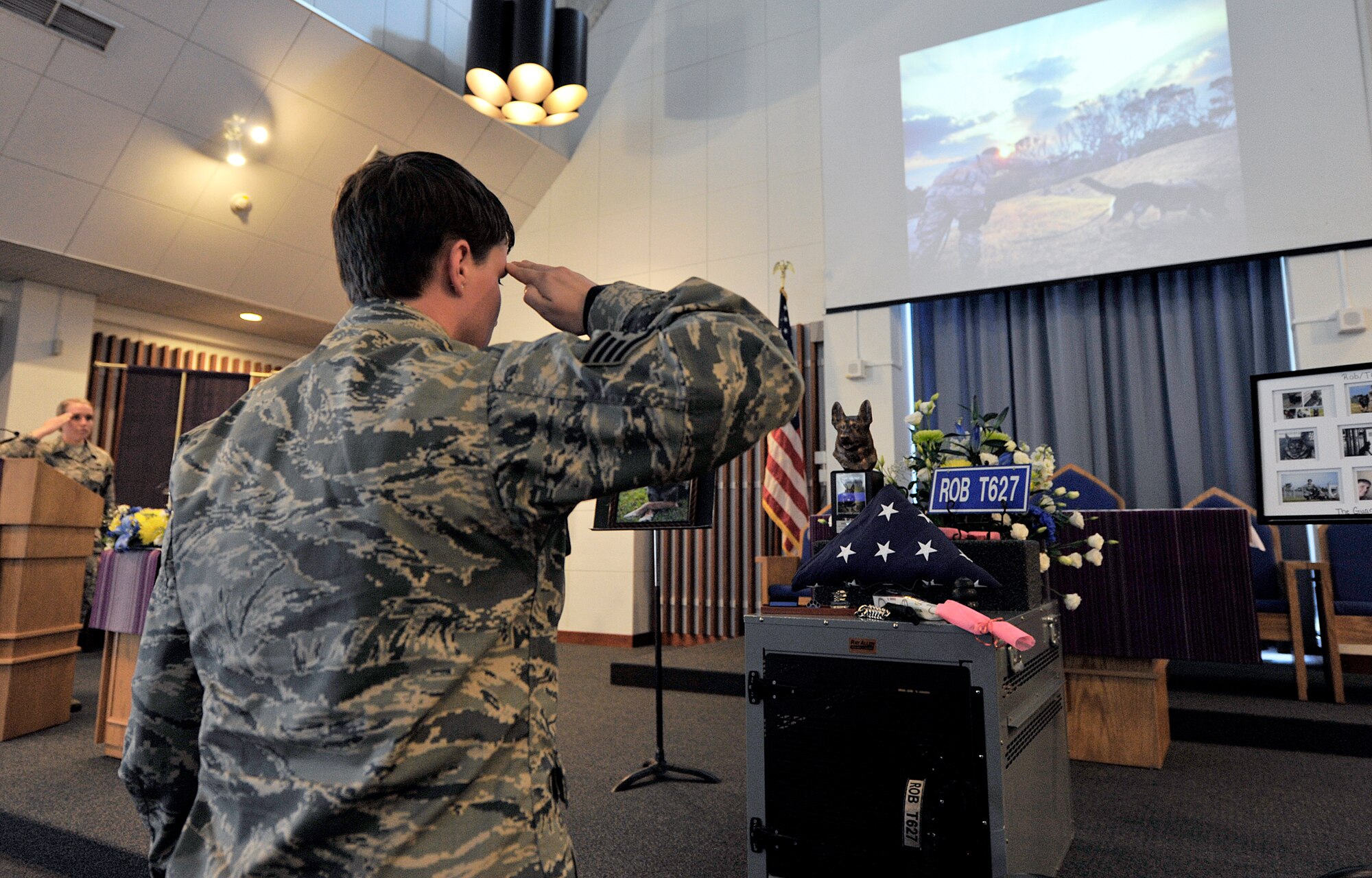 U.S. Air Force Staff Sgt. Sara Sturgess, 18th Security Forces Squadron military working dog handler, renders a salute during the memorial of her MWD Rob at Chapel 1, Feb. 10, 2016, at Kadena Air Base, Japan. Rob entered the USAF July 3, 2012, and was certified as a dual purpose patrol explosive detector dog at Lackland Air Force Base, Texas May 15, 2013. (U.S. Air Force photo by Naoto Anazawa)