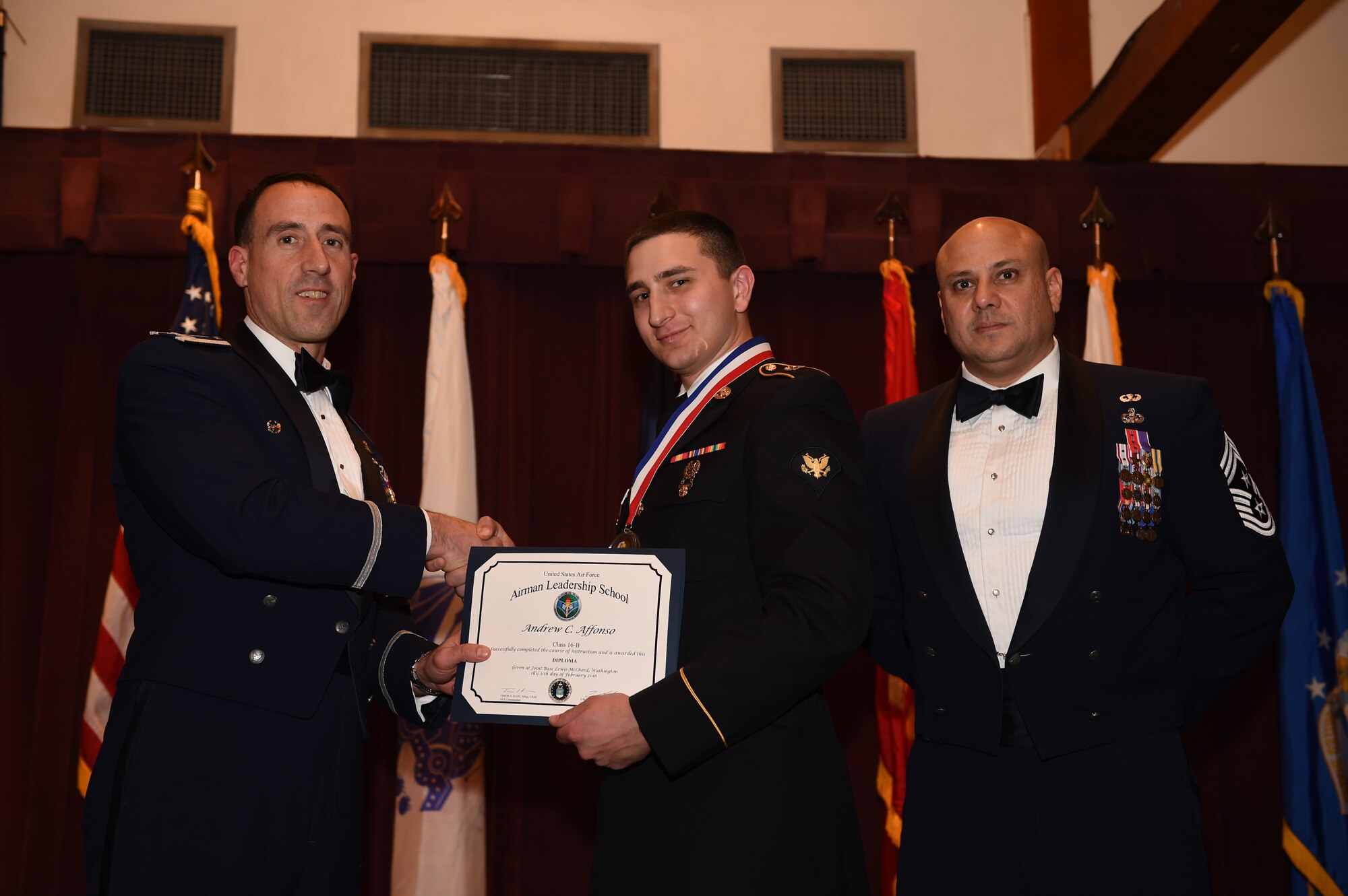 Spc. Andrew Affonso, Henry H. Lind NCO Academy information technology specialist, receives his graduation certificate at the Julius A. Kolb Airman Leadership School graduation Feb. 10, 2016, at Joint Base Lewis-McChord, Wash. Affonso is the first Soldier to graduate the six-week ALS course here at McChord Field. (U.S. Air Force photo/Staff Sgt. Naomi Shipley)