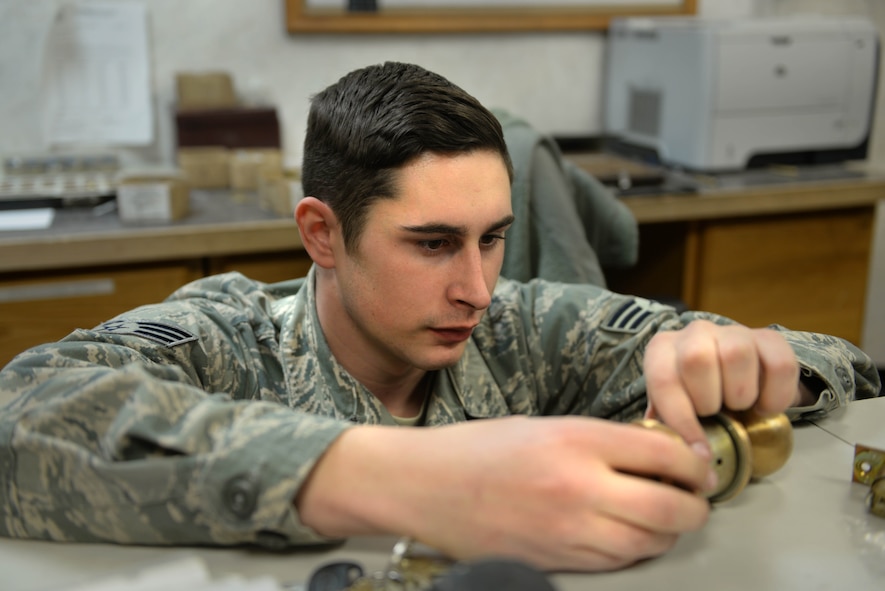 Senior Airman Ian Jerls, a structural journeyman assigned to the 5th Civil Engineer Squadron, assembles a door handle at Minot Air Force Base, N.D., Feb. 11, 2016. The 5th CES lock shop creates lock cores and keys to ensure building security throughout Minot AFB. (U.S. Air Force photo/ Airman 1st Class Jessica Weissman)