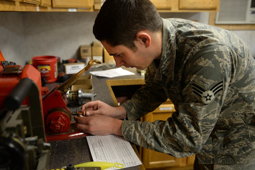 Senior Airman Ian Jerls, a structural journeyman assigned to the 5th Civil Engineer Squadron, cuts a key at Minot Air Force Base, N.D., Feb. 11, 2016. Unique cuts are specific to each key to ensure they match the intended lock core. (U.S. Air Force photo/ Airman 1st Class Jessica Weissman)