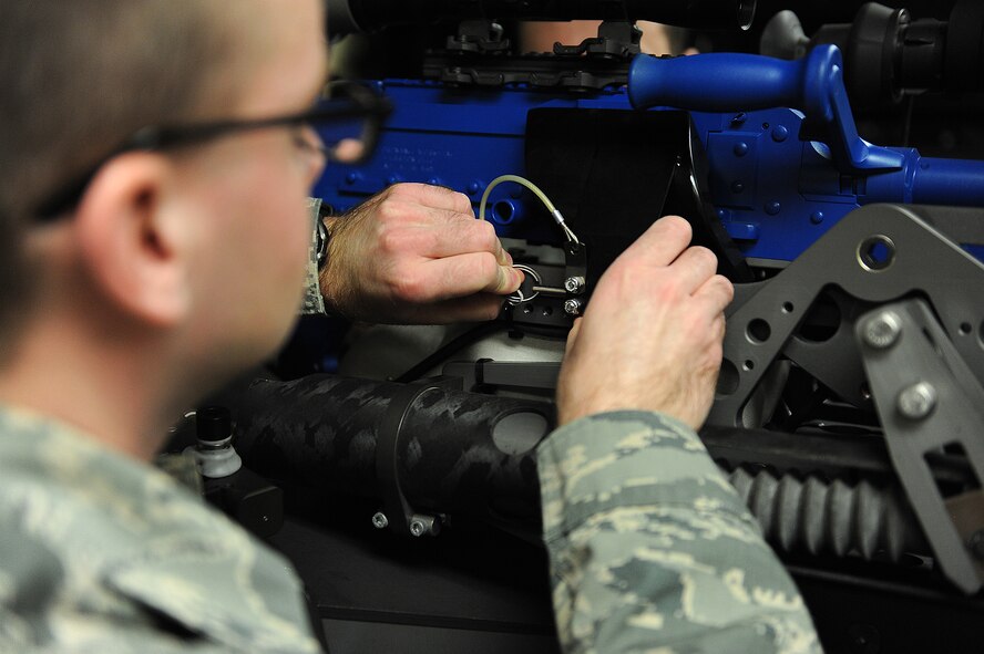 Airman 1st Class William Dicken, 5th Communications Squadron intrusion detection systems technician, troubleshoots the trigger actuator of the remote target engagement system at Minot Air Force Base, N.D., Jan. 29, 2016. The RTES is a remotely operated M240B machine gun used in the protection of Priority Level 1 resources on Minot Air Force Base. (U.S. Air Force photo/Senior Airman Kristoffer Kaubisch)