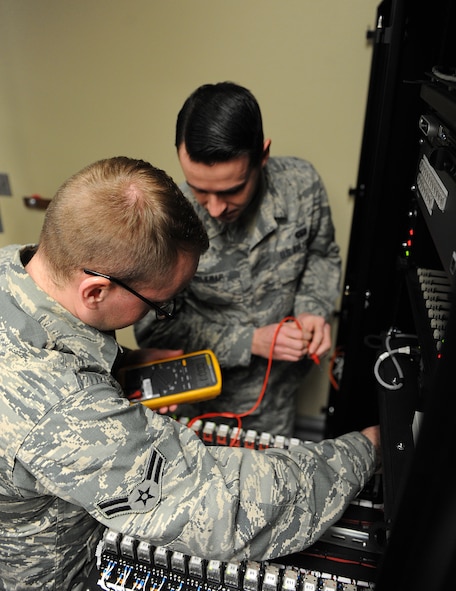 Airman 1st Class William Dicken and Airman 1st Class Thomas Belknap, 5th Communications Squadron intrusion detection systems technicians troubleshoot the server components of the Remote Target Engagement System at Minot Air Force Base, N.D., Jan. 29, 2016. The component includes servers, video cards and a computer. (U.S. Air Force photo/Senior Airman Kristoffer Kaubisch)