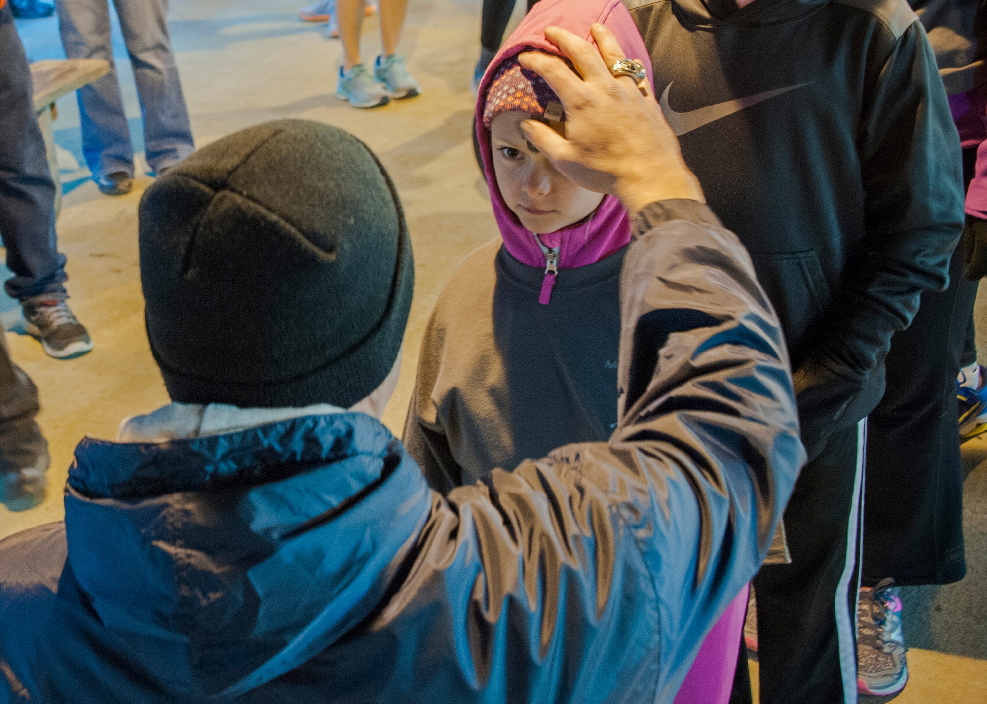 A young girl, receives an optional little black cross of ashes from Capt. Edward Ramatowski, a Hurlburt Field chaplain during the Ash Wednesday 5K Feb. 10 at Eglin Air Force Base, Fla. Approximately 115 runners and 15 volunteers endured a 29-degree temperature to participate in the run. Ash Wednesday marks the beginning of the Lent season for Christians. (U.S. Air Force photo/Ilka Cole)
