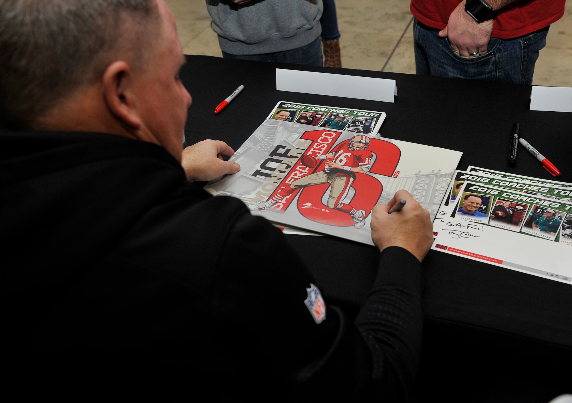 Chip Kelly, San Francisco 49ers head coach, signs his autograph for a fan during the 2016 Coaches Tour Feb. 14, 2016, at Ramstein Air Base, Germany. The coaches took time to travel here to meet with fans, sign autographs and have lunch with wounded warriors. (U.S. Air Force photo/Airman 1st Class Larissa Greatwood)
