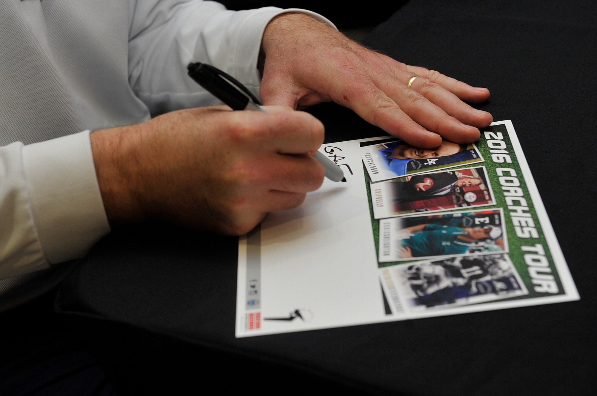 Troy Calhoun, Air Force Academy head coach, signs his autograph for a fan during the 2016 Coaches Tour Feb. 14, 2016, at Ramstein Air Base, Germany. The coaches met with fans in the Kaiserslautern Military Community Center and met with Airmen and wounded warriors during the tour. (U.S. Air Force photo/Airman 1st Class Larissa Greatwood) 