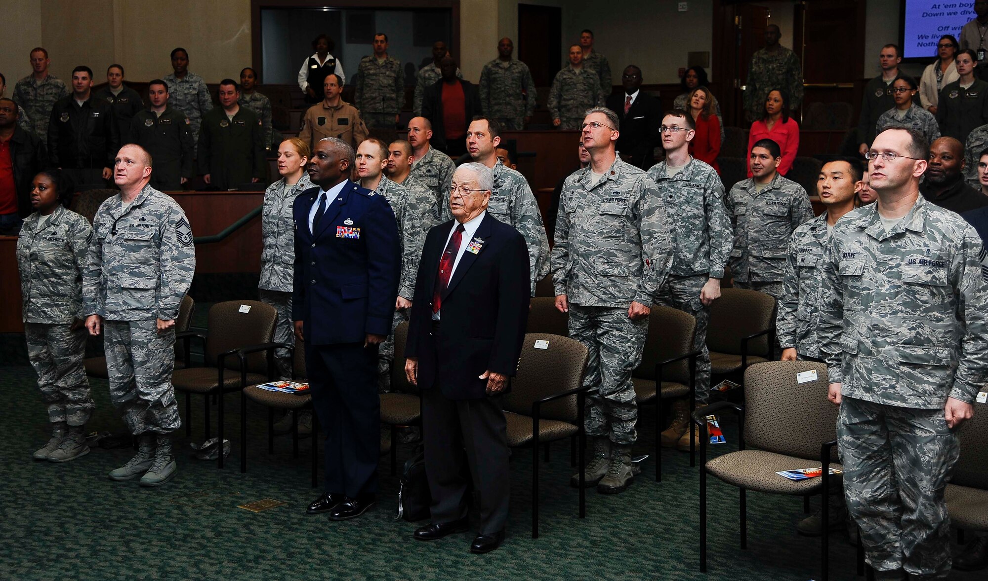 (Center Right) Retired Lt. Col. George E. Hardy, a Tuskegee Airman, and Col. Reginald Godbolt, commander of the 6th Maintenance Group, stand with the audience and sing the Air Force song during the “A Salute To A Living Legend” event at MacDill Air Force Base, Fla., Feb. 11, 2016. The event was held in the Davis Conference Center, which was named in honor of the late Gen. Benjamin O. Davis Jr. who was also a Tuskegee Airman and served as commander of the 99th Fighter Squadron and 332nd Fighter Group during World War II. (U.S. Air Force photo by Senior Airman Vernon L. Fowler Jr.)
