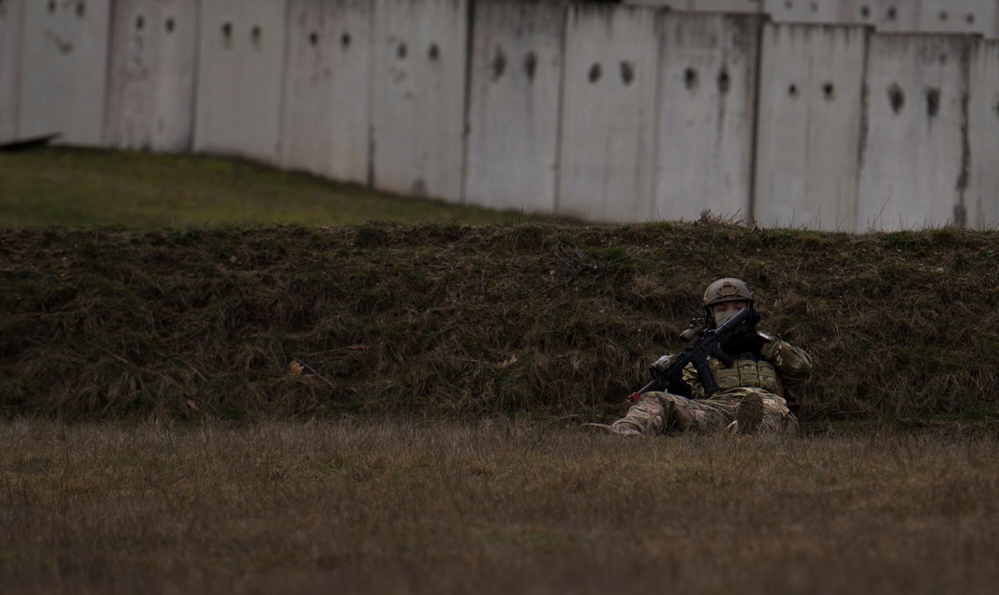 Senior Airman Martin Dietrich, 2nd Air Support Operations Squadron tactical air control party member, takes cover behind a hill during training at U.S. Army Garrison Bavaria in Vilseck, Germany, Feb. 8, 2016. The training consisted of Airmen calling in close air support, neutralizing opposing forces and practicing medical evacuation by helicopter. By conducting the training in an urban environment the ASOS team was forced to think about proper tactics to ensure they weren’t caught in the line of fire. (U.S. Air Force photo/Senior Airman Jonathan Stefanko) 
