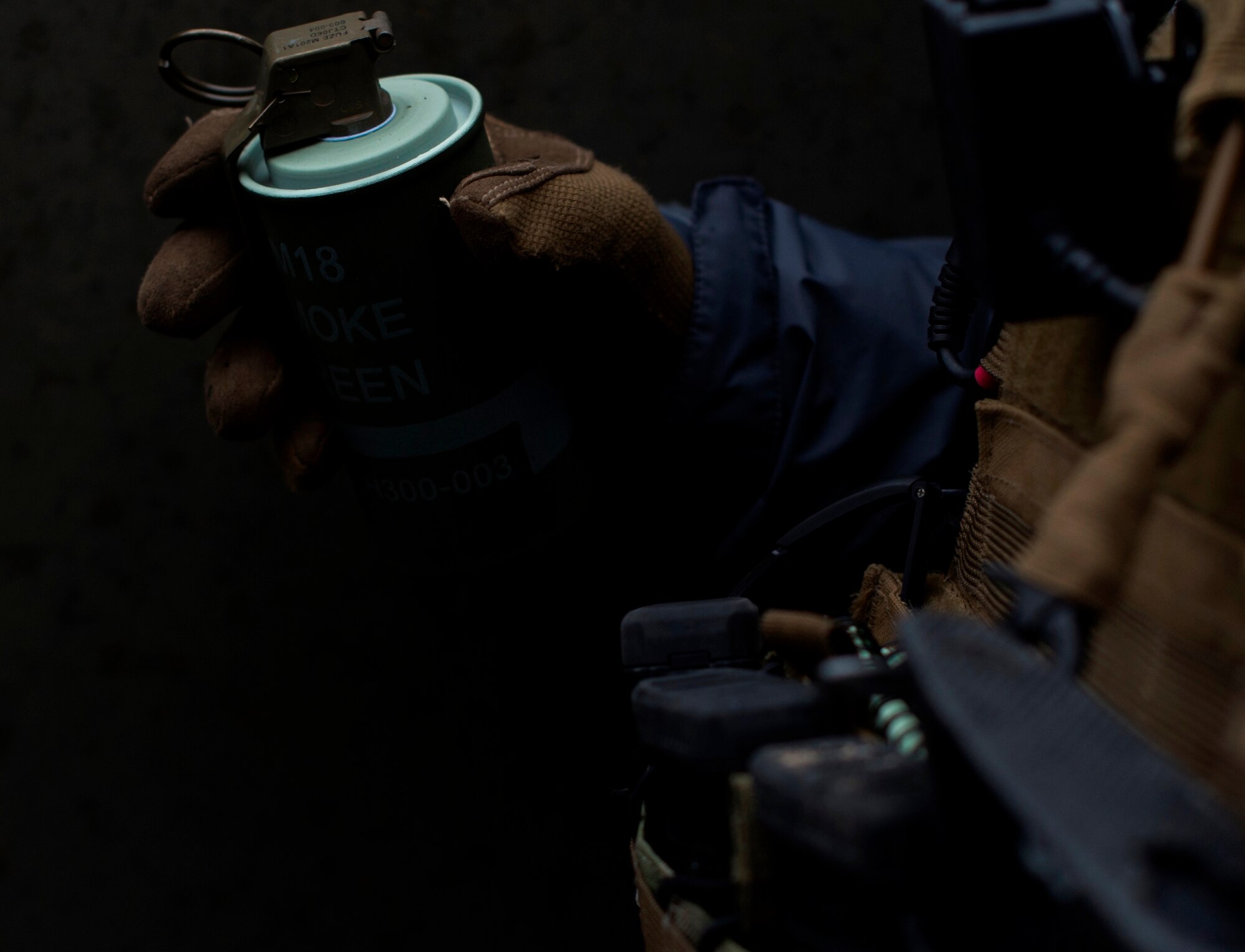 Senior Airman Ericson Galinato, 2nd Air Support Operations Squadron tactical air control party member, holds a smoke grenade during training at U.S. Army Garrison Bavaria in Vilseck, Germany, Feb. 9, 2016. The training consisted of calling in close air support, neutralizing opposing forces and practicing medical evacuation by helicopter. (U.S. Air Force photo/Senior Airman Jonathan Stefanko)